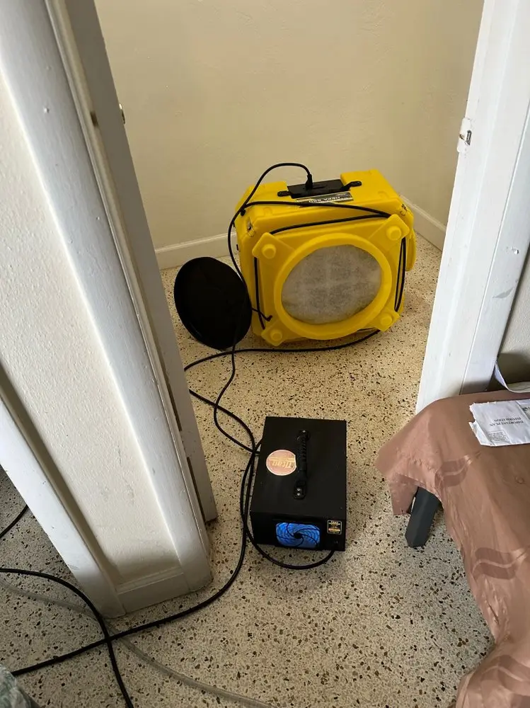 Air scrubber and drying unit set up in a home hallway during water damage restoration