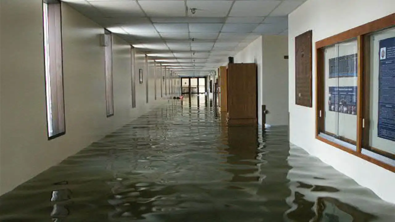 Flood water covering the floor of a long commercial building hallway